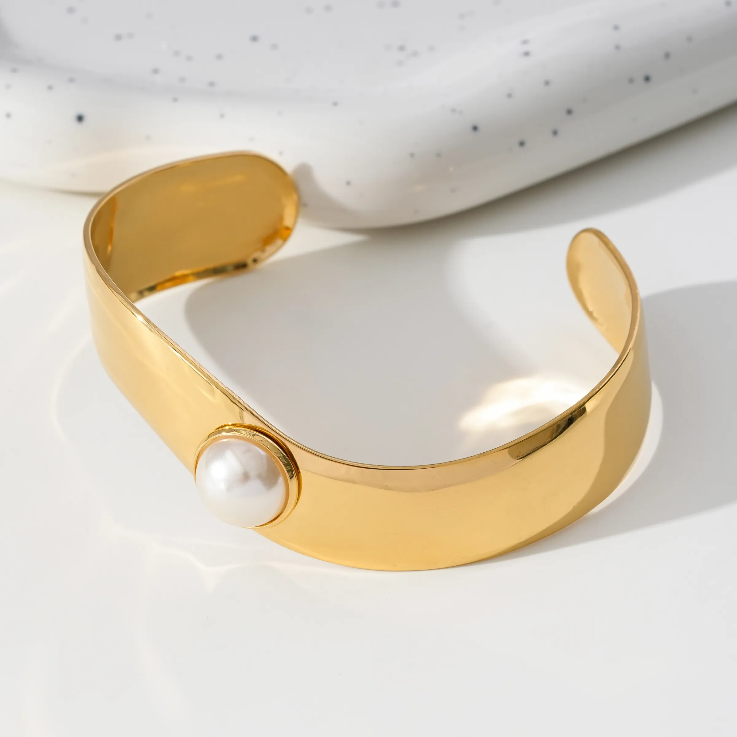 Goldenes Armband, offener Armreif, gewelltes Band, verziert mit Perle